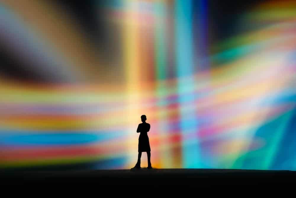 What's AIXD? explains Joanne Z. Tan, thought leader, the originator of AIXD, AI Experience Design, global brand strategist (image of a man with colored lights background)